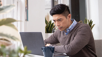 hombre mirando una computadora portátil